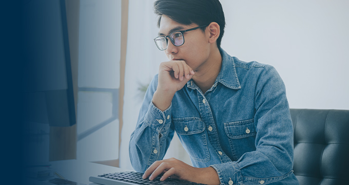 A man sitting at a desk in front of a computer