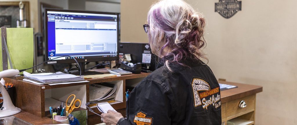 Woman sitting at a desk using LightSpeed DMS on a desktop computer