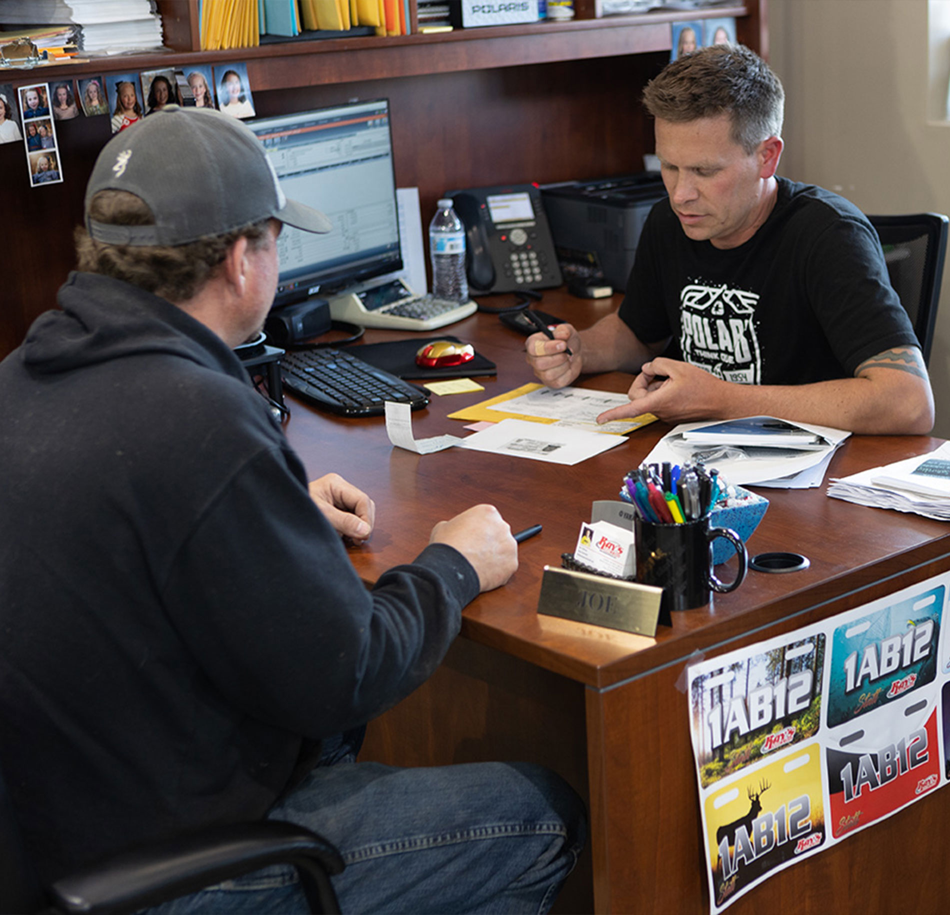 A salesman sitting at his desk with a customer